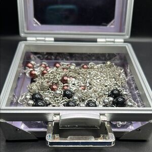 Lot of four necklaces and two pairs of earrings in lucite box.